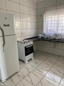 a kitchen with a stove and a white refrigerator at Casa próximo à rodoviária e centro in Rondonópolis