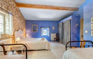 a bedroom with blue walls and two beds at Belle Maison À Lacoste in Lacoste