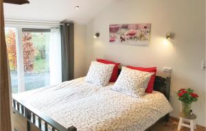a bedroom with a bed with red pillows and a window at Boszicht in Baarle-Nassau