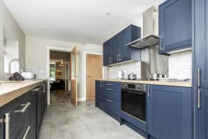 a kitchen with blue cabinets and a counter top at Eller Cottage in Windermere +14 photos