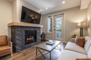 a living room with a fireplace with a tv at New 1Bd Luxe King Suite with Superb Mtn View in Canmore