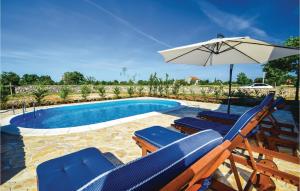 a group of chairs and an umbrella next to a pool at Holiday Home Drinovci With A Fireplace 444 in Drinovci +38 photos