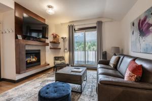 a living room with a couch and a fireplace at Stunning Silver Creek 1Br Mtn view penthouse in Canmore