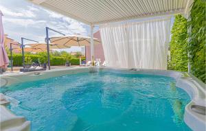 a large swimming pool with an umbrella in a yard at Lovely Home In Brodarica With Jacuzzi in Brodarica +56 photos