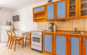 kuchnia ze stołem, zlewem i kuchenką w obiekcie Apartment Krnica Xcii w mieście Krnica