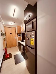 a kitchen with a stainless steel refrigerator and a microwave at Serenity Bali Condotel in San Fernando