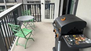 a grill on a balcony with a table and chairs at New 1Bd Luxe King Suite with Superb Mtn View in Canmore