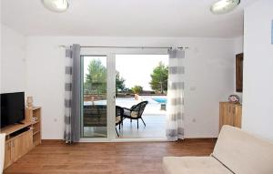 a living room with a sliding glass door leading to a patio at Lovely Home In Supetar in Supetar