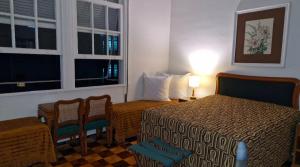 een hotelkamer met een bed en stoelen en een raam bij Suite Palácio Quitandinha in Petrópolis