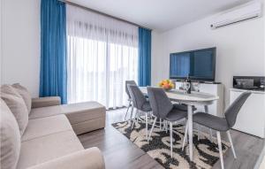 a living room with a table and chairs and a couch at Amazing Apartment In Biograd Na Moru in Biograd na Moru