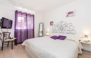 a bedroom with a large white bed with purple accents at 4 Bedroom Beautiful Home In Rukavac in Rukavac