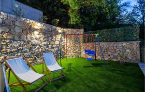 two swings in a yard next to a stone wall at 4 Bedroom Beautiful Home In Rukavac in Rukavac +50 photos