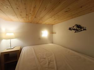 a bedroom with a bed with a wooden ceiling at 4-6 pers ski pieds Belle Plagne Les Gémeaux in La Plagne Tarentaise
