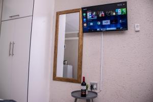 a mirror on a wall with a bottle of wine on a table at Nsuku Guest House in Phalaborwa