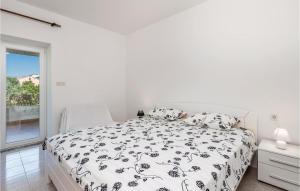 a white bedroom with a bed and a window at 2 Bedroom Gorgeous Apartment In Barbat in Barbat na Rabu