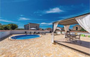 eine Terrasse mit Pool und Tisch und Stühlen in der Unterkunft Gorgeous Home In Pakostane With Kitchen in Pakoštane + 31 Fotos