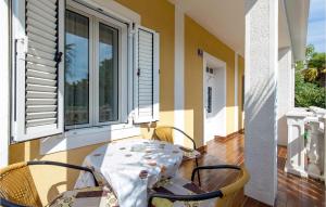 stół i krzesła na werandzie z oknem w obiekcie Nice Apartment In Omisalj With Wifi w mieście Omišalj