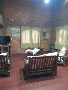 ein Wohnzimmer mit Holzstühlen und einem TV in der Unterkunft Paraje del molino Loft in Colón