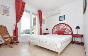 ein Schlafzimmer mit einem Bett und einem Stuhl und einem Fenster in der Unterkunft Gorgeous Home In Roquebrune-Sur-Argens in Saint-Peïre-sur-Mer