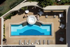 an overhead view of a swimming pool with people sitting around it at Flat Hotel Executivo Vila Olímpia (Apto 2509) in São Paulo
