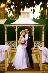a bride and groom are posing for a picture at Atrium Hotel Mandurah in Mandurah