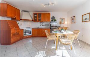ラバックにあるAmazing Apartment In Rabac With Wifiのキッチン(テーブル、椅子付)