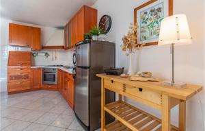 ラバックにあるAmazing Apartment In Rabac With Wifiのキッチン(ステンレス製の冷蔵庫、木製テーブル付)