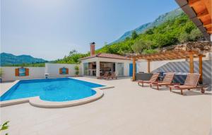 a villa with a swimming pool and some chairs at Lovely Home In Vrgorac With Sauna in Vrgorac +34 photos