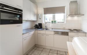 a white kitchen with white cabinets and a sink at Oesterbaai -5C2 in Wemeldinge