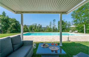 un patio con sofá y piscina en Le Silerchie, en Camaiore