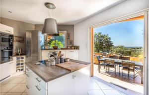 eine Küche mit einem großen Fenster und einem Tisch mit Stühlen in der Unterkunft Nice Home In La Londe Les Maures in La Londe-les-Maures