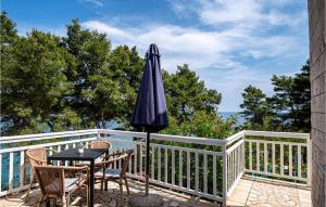 ルンバルダにあるHoliday Home Przina Ivのテーブルと椅子と傘のあるパティオ