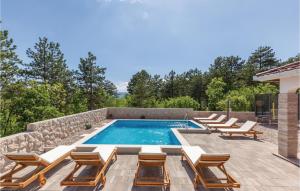 ein Swimmingpool mit Liegestühlen und einer Gruppe vonvisorvisorvisor in der Unterkunft Four-Bedroom Holiday Home In Imotski in Imotski