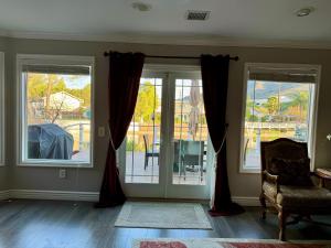 a living room with two windows and a chair at Lakefront House With Breath Taking Views in Agoura Hills