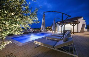 a swimming pool with lounge chairs and an umbrella at 4 Bedroom Cozy Home In Nin in Nin
