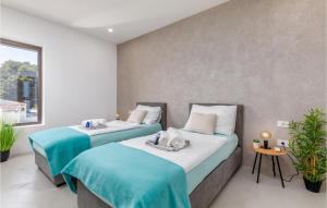 two beds with blue and white sheets in a room at 3 Bedroom Gorgeous Home In Pula in Pula +41 photos