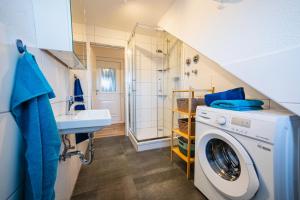 a bathroom with a washing machine and a sink at Zentrale Wohlfühlwohnung - Ideal für Ihren Urlaub oder die Geschäftsreise in Magdeburg