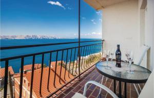 einen Balkon mit einem Tisch und Weingläsern darauf in der Unterkunft 3 Bedroom Awesome Apartment In Senj in Senj