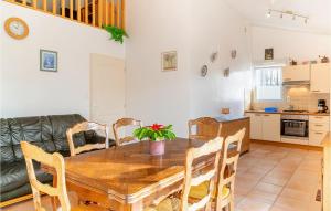 ラ・フォット・シュル・メールにあるBeautiful Home In La Faute Sur Merの木製のテーブルと椅子のあるキッチンとダイニングルーム