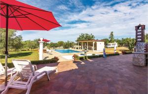 une terrasse avec un parasol rouge, des chaises et une piscine dans l'établissement Apartment Peroj Ii, à Vodnjan 32 autres photos