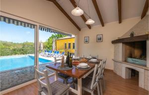 jadalnia ze stołem i kominkiem w obiekcie Holiday Home Strmac 25 With Outdoor Swimmingpool w mieście Strmac