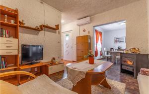 a living room with a table and a television at Awesome Apartment In Premantura in Premantura