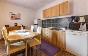 a small kitchen with a table and a refrigerator at Awesome Apartment In Premantura in Premantura