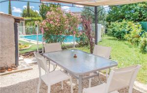 Una mesa y sillas en un patio trasero con piscina. en One-Bedroom Holiday Home In Aubignan, en Aubignan