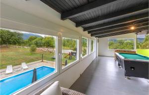 a pool room with a pool table and a large window at Lovely Home In Stikada With Sauna in Štikada