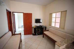 a living room with a couch and a television at Casa em Baependi-Até 7 pessoas in Baependi