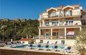 a hotel with a swimming pool and lounge chairs at Nice Apartment In Poljica in Poljica