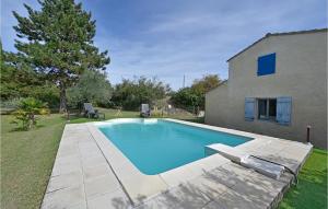 a swimming pool in a yard next to a house at 3 Bedroom Nice Home In Mazan in Mazan