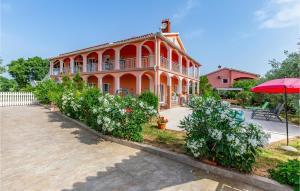 a large orange building with an umbrella in front of it at 3 Bedroom Amazing Home In Liznjan in Šišan