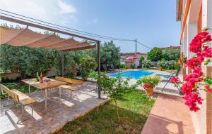 a patio with a table and chairs and a pool at 3 Bedroom Amazing Home In Liznjan in Šišan